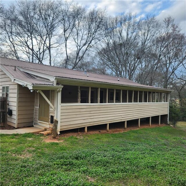 582 S Cherokee Rd, Social Circle, GA 30025 - back of house with a lawn, metal roof, and a sunroom