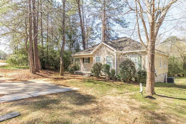 view of front facade with crawl space, a garage, cooling unit, and a front lawn