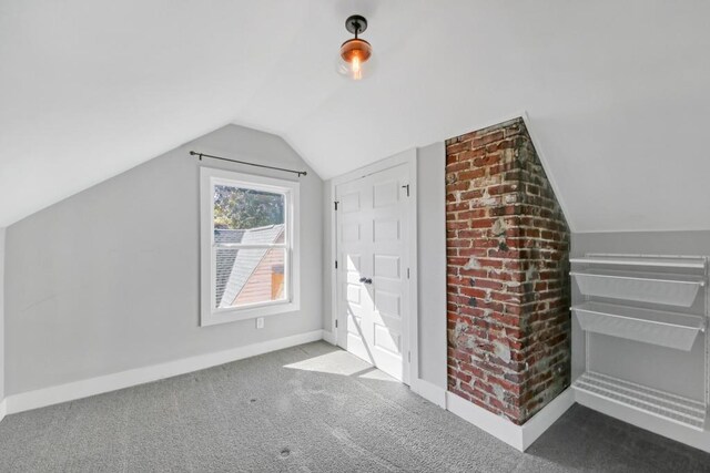 bonus room featuring dark carpet and lofted ceiling