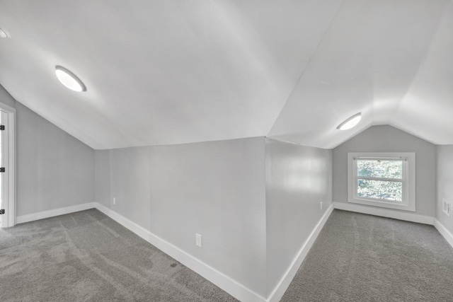 additional living space with vaulted ceiling and light carpet