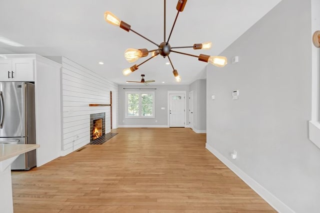 unfurnished living room featuring light hardwood / wood-style floors and a notable chandelier