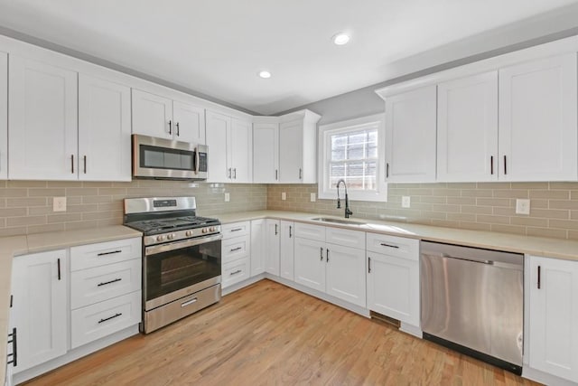 kitchen featuring white cabinets, stainless steel appliances, and light hardwood / wood-style floors