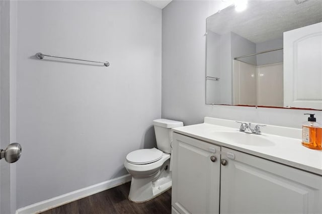 bathroom with toilet, vanity, a shower, and hardwood / wood-style floors