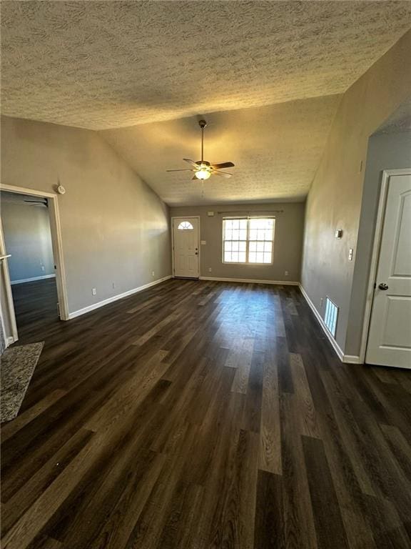 unfurnished living room with ceiling fan, dark wood-type flooring, a textured ceiling, and vaulted ceiling