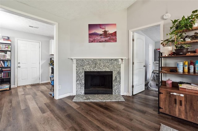 living room featuring a textured ceiling, a premium fireplace, lofted ceiling, and dark wood-type flooring