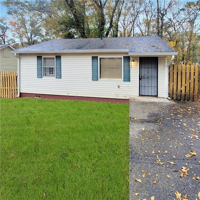 ranch-style house with a front lawn and fence