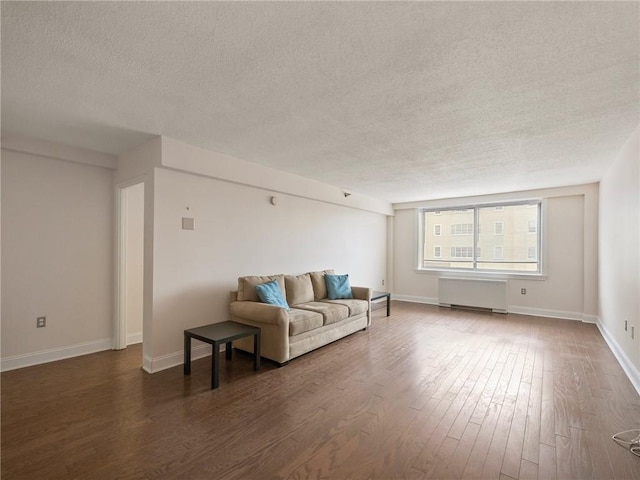 living area featuring radiator, a textured ceiling, and wood finished floors