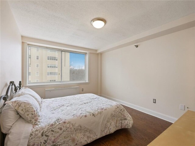 2479 Peachtree Rd NE Unit 407, Atlanta, GA 30305 - bedroom with a textured ceiling, dark wood finished floors, and baseboards