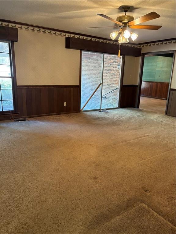 unfurnished room with a textured ceiling, ceiling fan, and light colored carpet