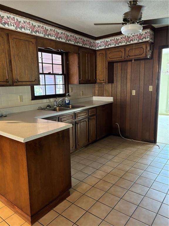 kitchen featuring dark brown cabinets, sink, and light tile patterned flooring