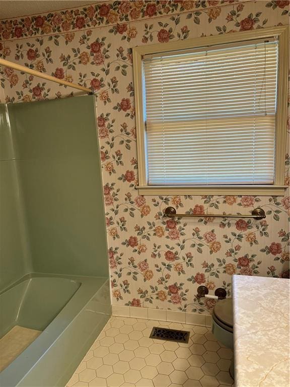 bathroom with toilet, vanity, and tile patterned flooring