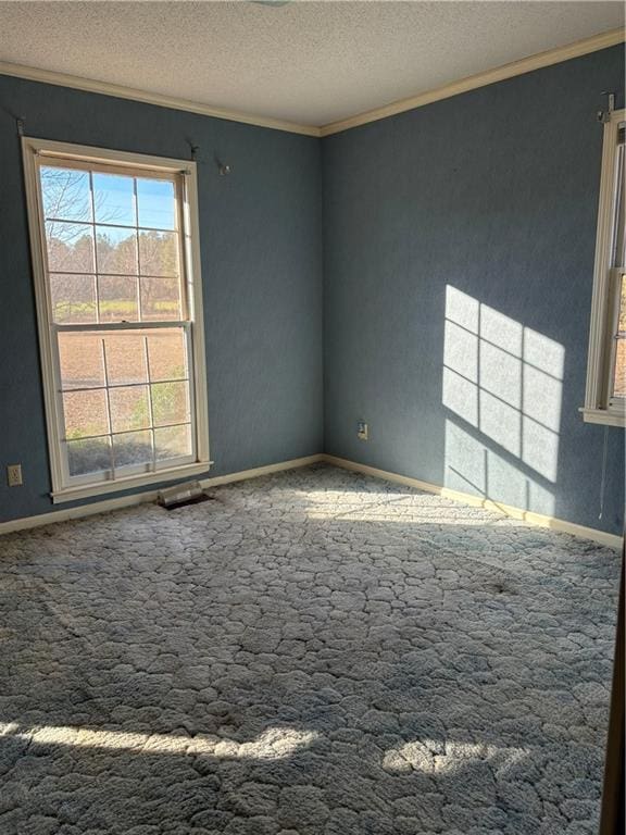 unfurnished room with carpet floors, a textured ceiling, and ornamental molding