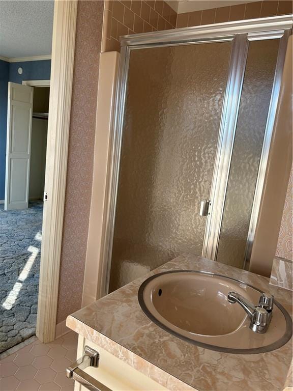 bathroom featuring tile patterned floors, a shower with door, and vanity