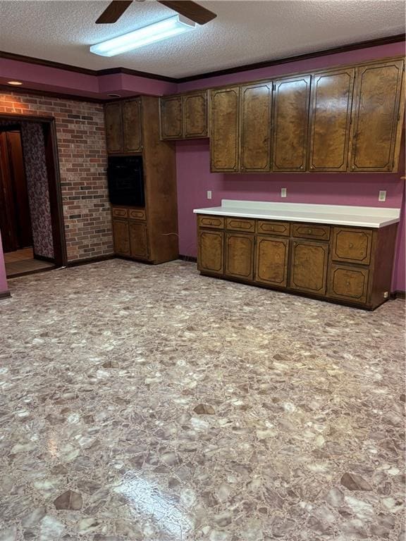 kitchen with brick wall, a textured ceiling, and dark brown cabinets