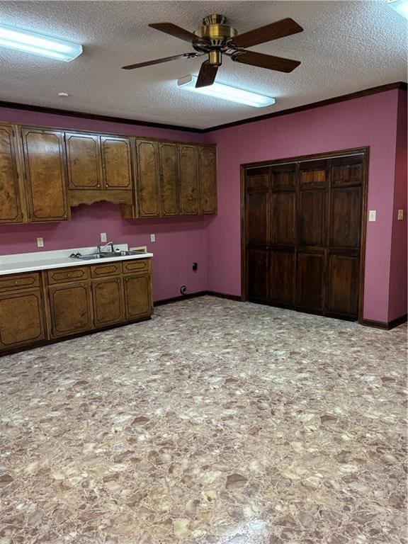 kitchen featuring sink, a textured ceiling, and dark brown cabinets