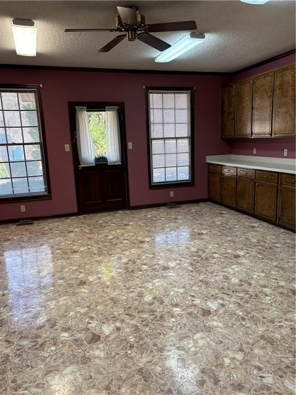 kitchen with ceiling fan, a textured ceiling, and dark brown cabinetry