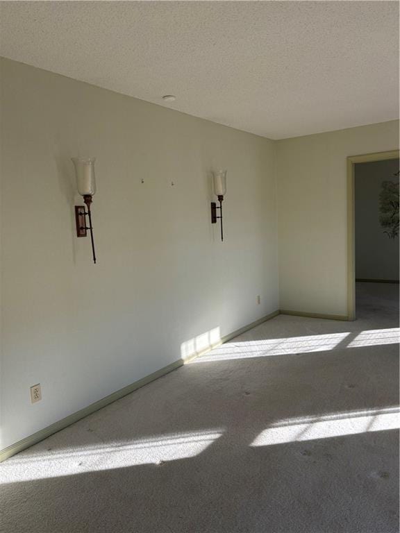 carpeted spare room with a textured ceiling