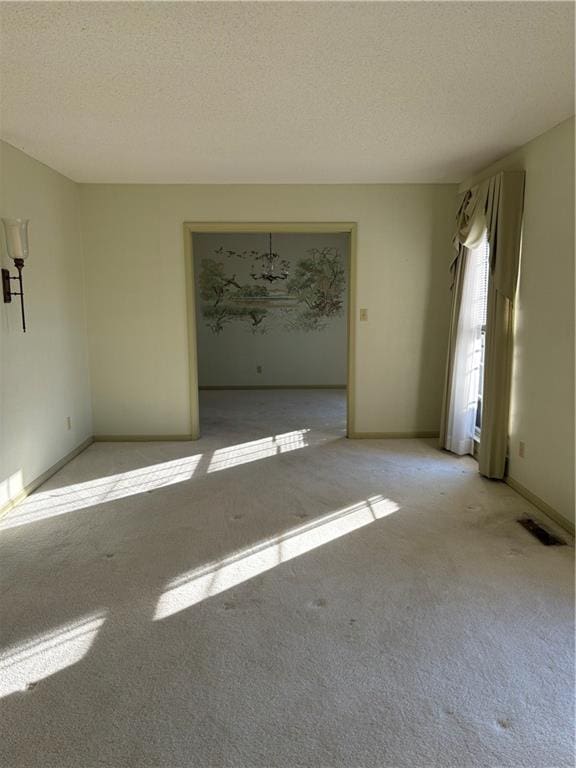 carpeted empty room with a textured ceiling