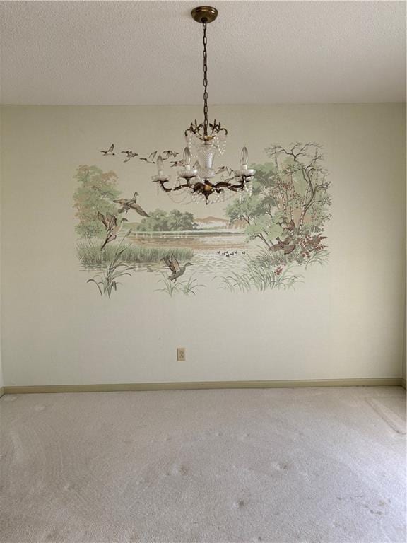 spare room with a textured ceiling and a notable chandelier