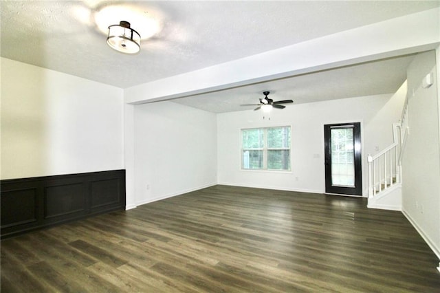 unfurnished living room featuring dark hardwood / wood-style flooring and ceiling fan