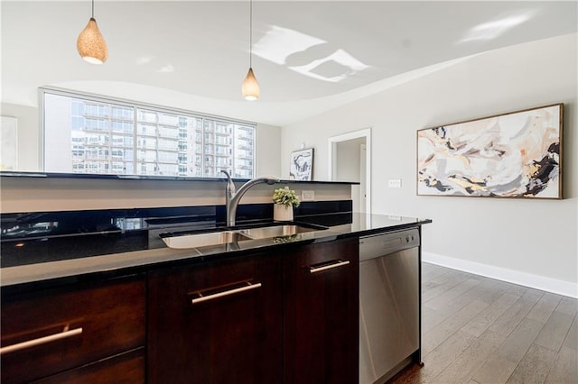 kitchen featuring dark wood-type flooring, dishwasher, sink, and hanging light fixtures