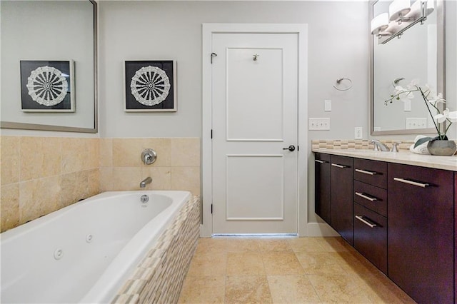 bathroom featuring tiled tub and vanity