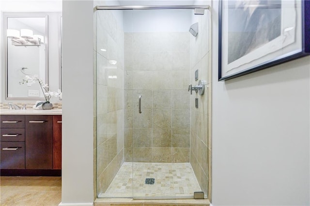 bathroom featuring a shower with door and vanity