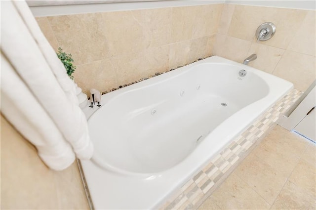 bathroom featuring a relaxing tiled tub and tile patterned flooring