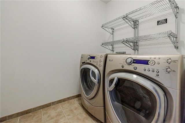 laundry area featuring washing machine and clothes dryer and light tile patterned floors