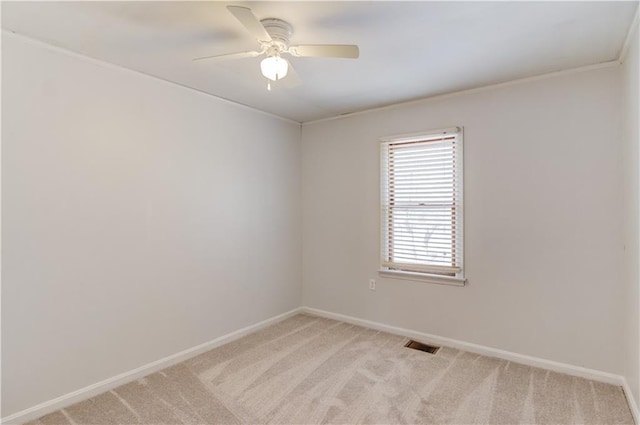 spare room featuring baseboards, ceiling fan, visible vents, and light colored carpet