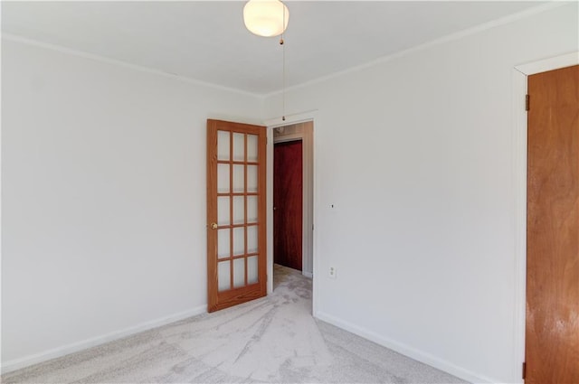 empty room featuring ornamental molding, carpet flooring, and baseboards