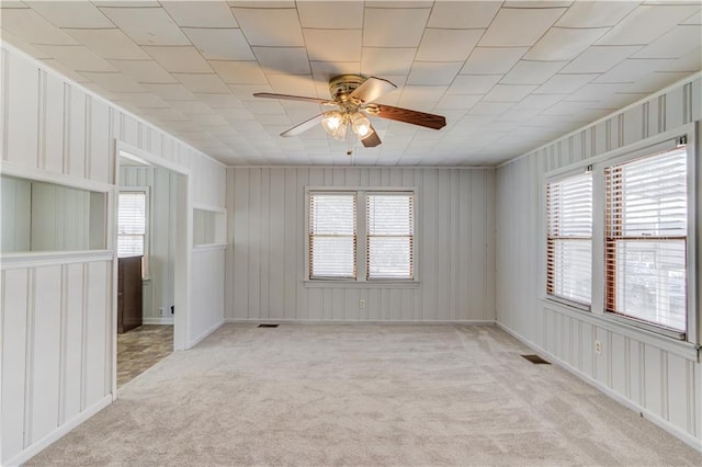 spare room featuring light carpet, a healthy amount of sunlight, and ceiling fan