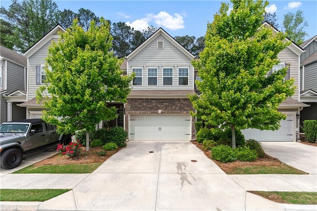 view of front of property featuring an attached garage, concrete driveway, and brick siding