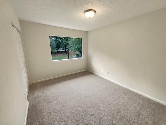 carpeted spare room with a textured ceiling