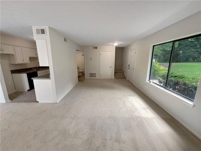 unfurnished living room featuring light carpet