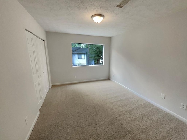 unfurnished bedroom with a closet, carpet floors, and a textured ceiling