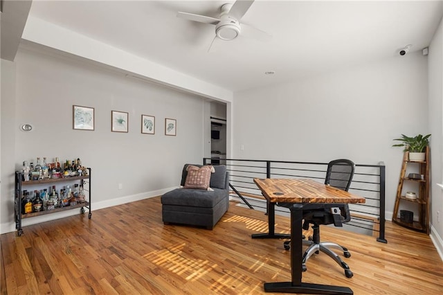 sitting room with ceiling fan, wood finished floors, and baseboards