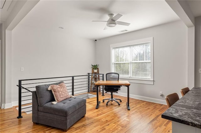 office area with visible vents, ceiling fan, light wood-style flooring, and baseboards