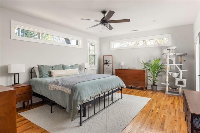 bedroom with ceiling fan, light wood-type flooring, and visible vents