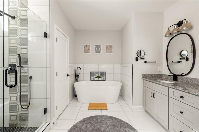 bathroom featuring tile walls, a soaking tub, a stall shower, vanity, and tile patterned flooring