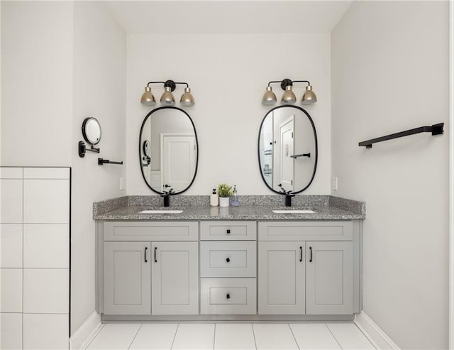 full bath featuring a sink, baseboards, and double vanity