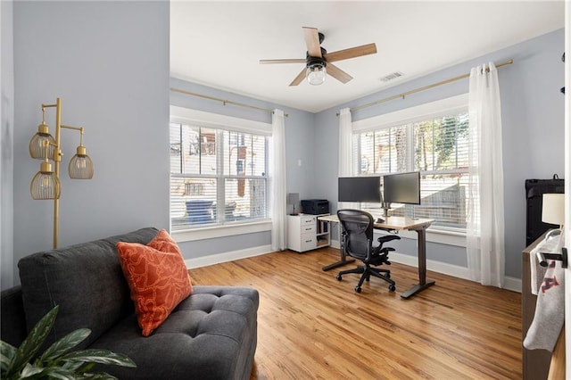 home office with light wood-type flooring, visible vents, baseboards, and a ceiling fan