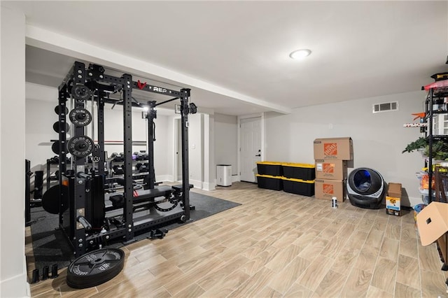 workout area featuring visible vents and light wood-style floors