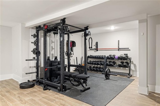 workout area featuring baseboards and wood finish floors