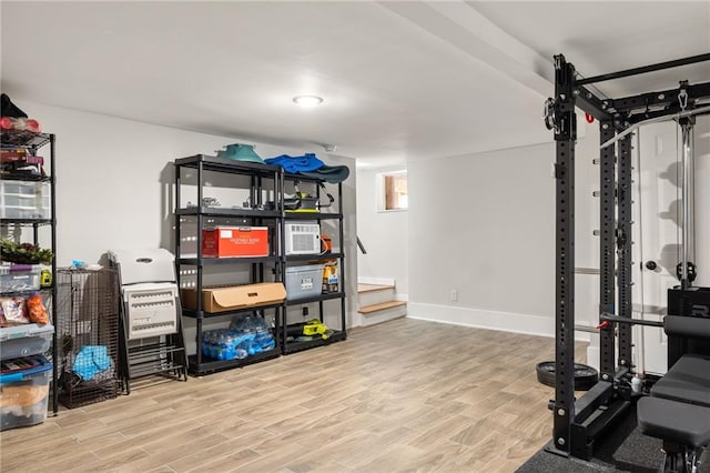 workout room with baseboards and wood finished floors