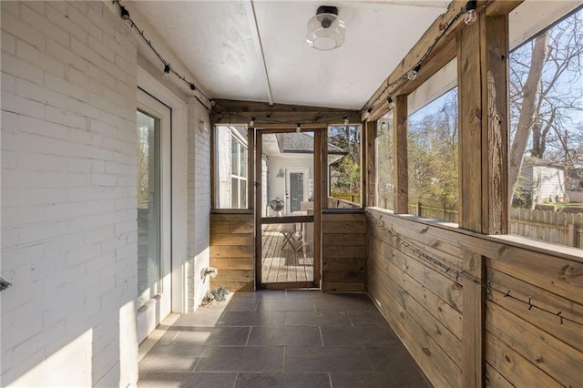 unfurnished sunroom featuring vaulted ceiling