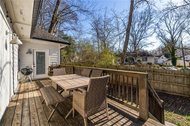 wooden deck with outdoor dining space and fence