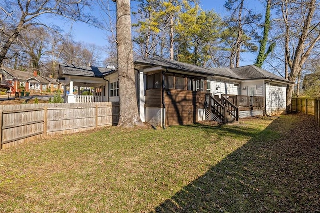 rear view of house featuring stairs, a lawn, and a fenced backyard