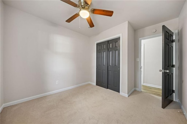 unfurnished bedroom with a closet, light colored carpet, and ceiling fan