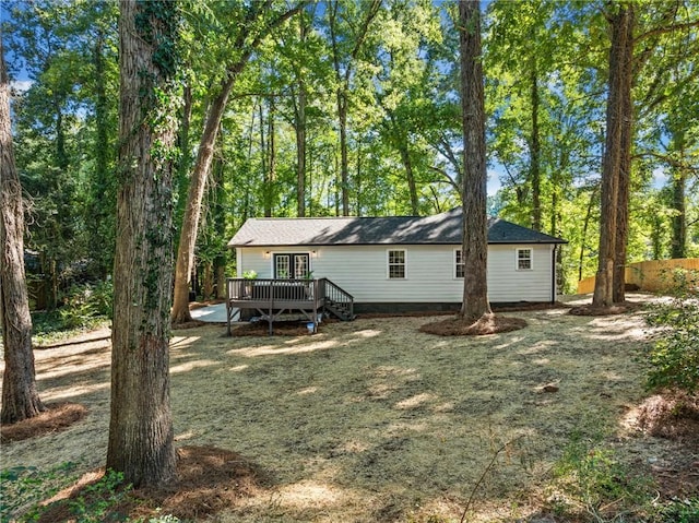 rear view of house featuring a deck and a lawn